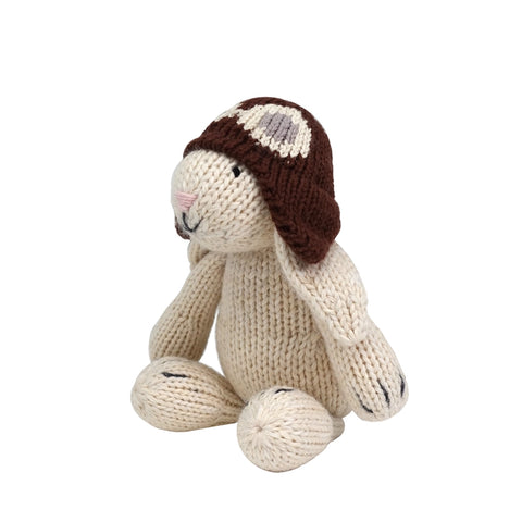 Knitted bunny toy wearing a brown hat on a white background