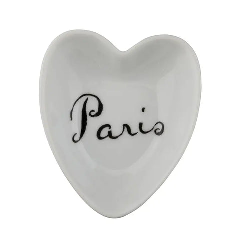 A white heart-shaped trinket dish. On the Inside is the name Paris in black cursive.