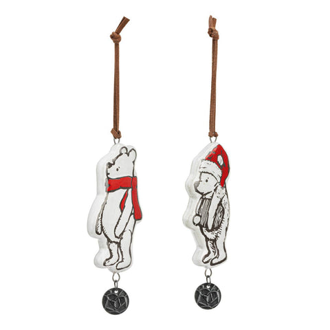 Two Winnie-the-Pooh Christmas ornaments. They are made of ceramic and have a small round metal disk hanging from them with a heart engraved on it. One ornament has Pooh Bear wearing a red scarf and the other a red hat. this picture shows them at an angle.