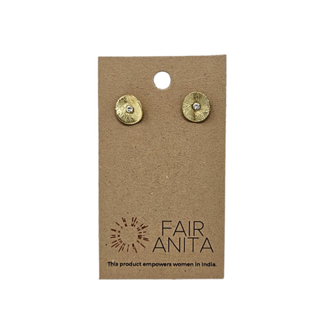 Gold stud earrings in the shape of a poppy flower. They are packaged on a brown slip of cardboard which has the brand name, "Fair Anita" on it.