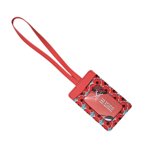 A red and light blue luggage tag with digitally manipulated poppies that are repeated and stacked on one another with the National WWI Museum and Memorial Intersections logo interlaced between. There is a plastic sleeve to slide a name tag into.