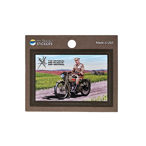 A vintage-style mini sticker showcases a person in classic WWI military attire riding a motorcycle on a country road. Text reads The National WWI Museum and Memorial. Made in the USA.