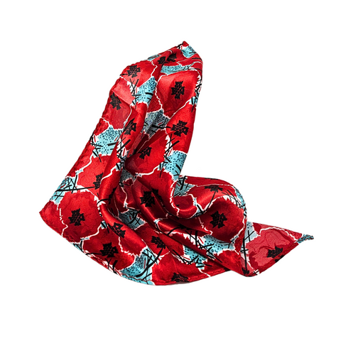 This image depicts a silk pocket square with digitally manipulated poppies that are repeated and stacked on one another with the National WWI Museum and Memorial Intersections logo interlaced between. The pocket square has a color theme of red poppies, with light blue accents. It is draped over a white  backdrop.