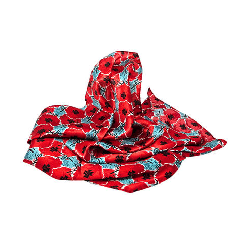 This image depicts a silk scarf with digitally manipulated poppies that are repeated and stacked on one another with the National WWI Museum and Memorial Intersections logo interlaced between. The scarf has a color theme of red poppies, with light blue accents. It is draped over a white backdrop.