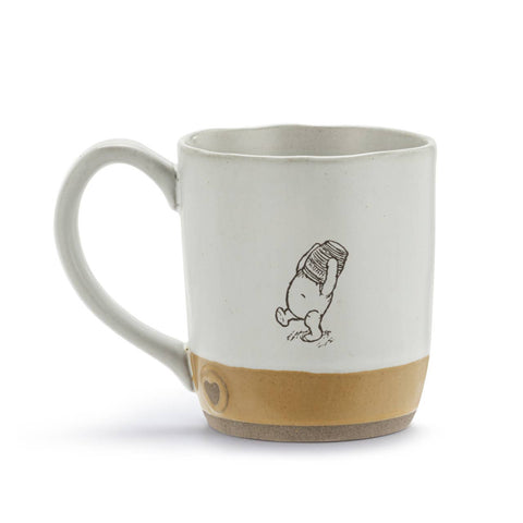 Ceramic mug with an image of Winnie-the-Pooh standing up with a jar of honey on his head. Text on the bottom reads, "sweet things are on the way".